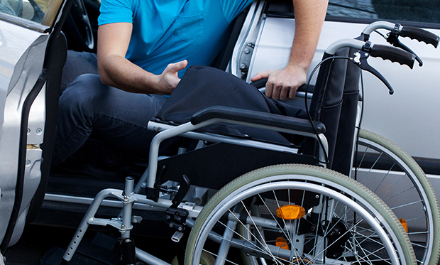 A man getting off his car to his wheel chair